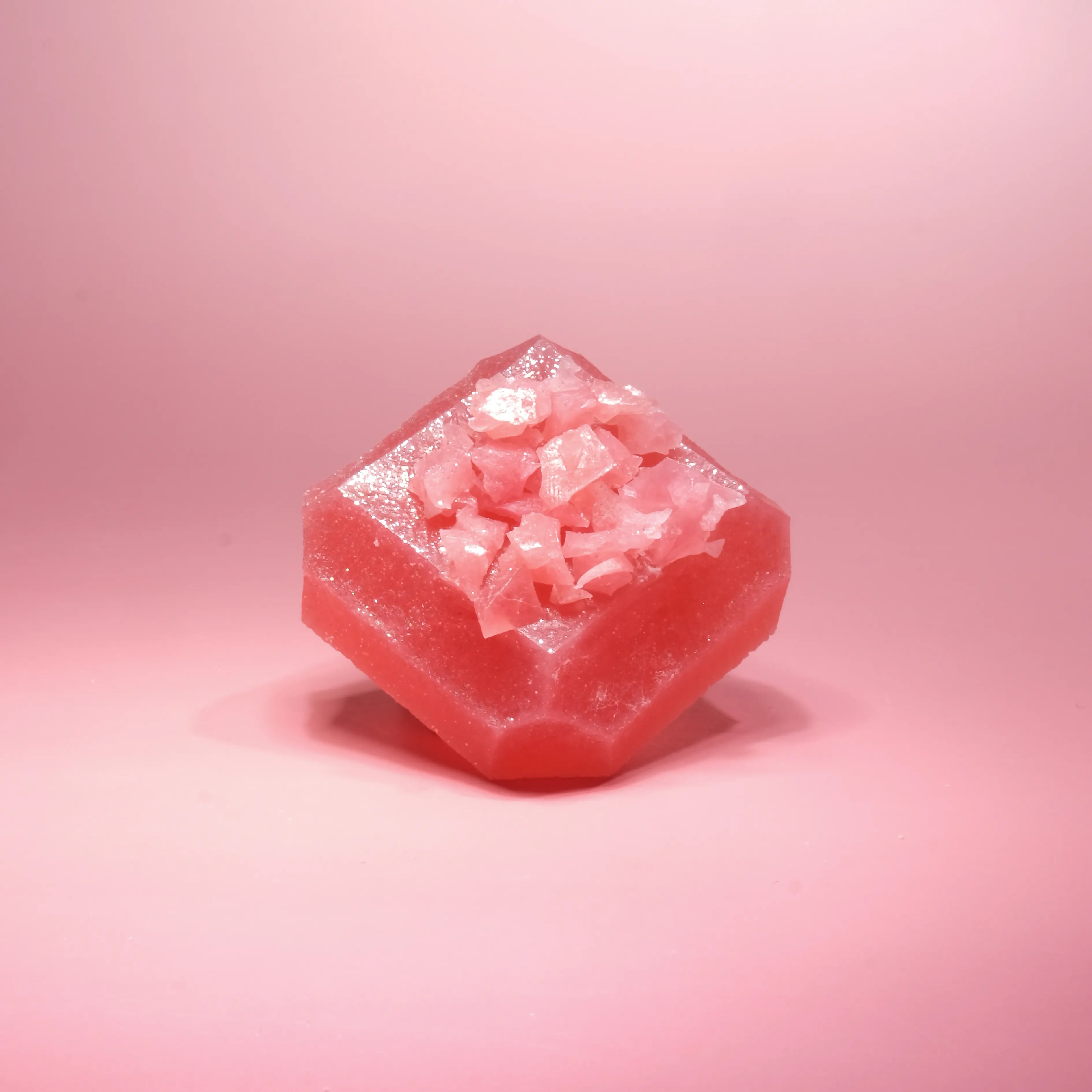 Pink gemstone-shaped crystal candy topped with translucent pink crushed crystal candy.