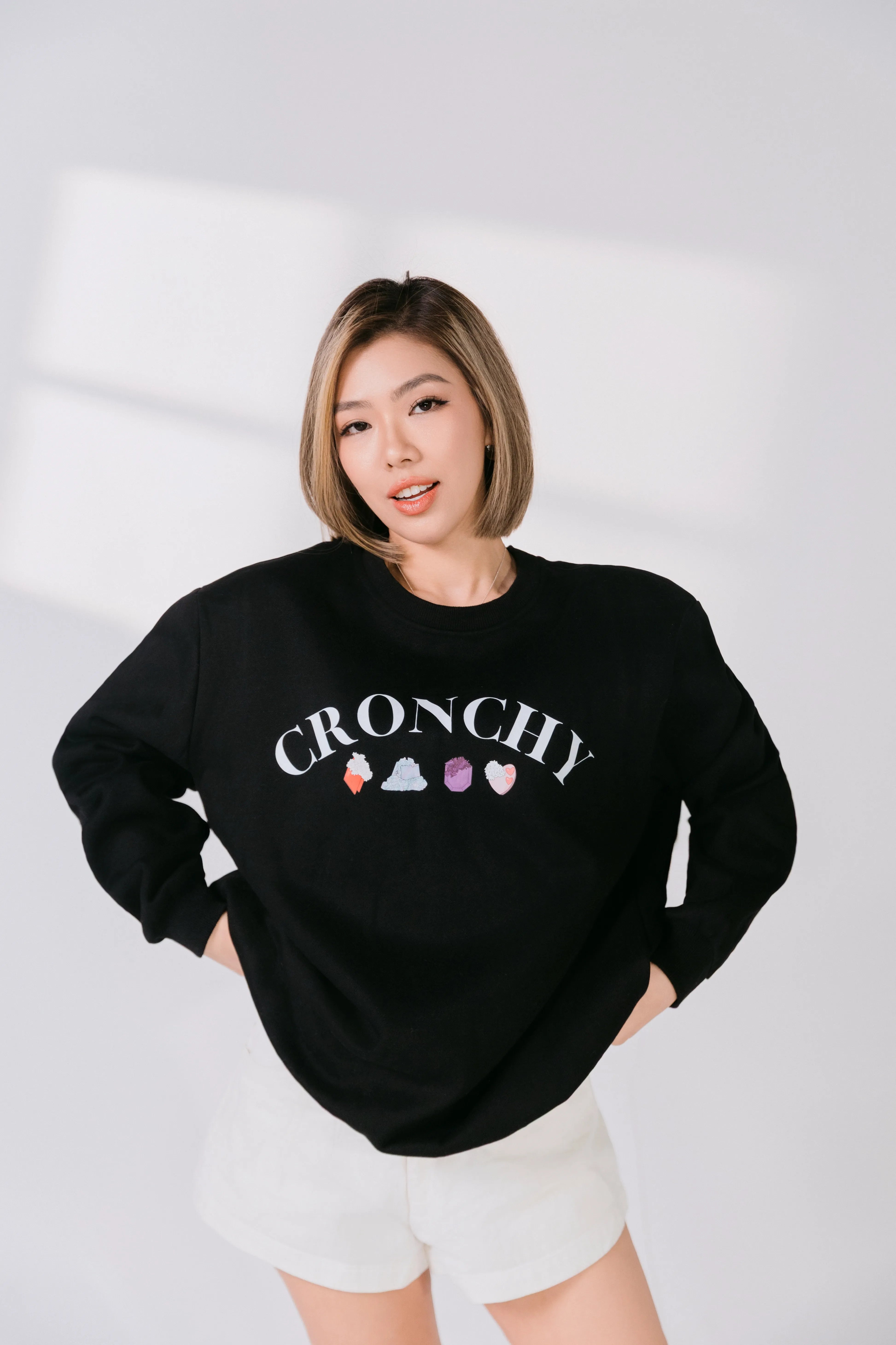 Model wearing black CRONCHY Silky Gem crewneck with white arched lettering.