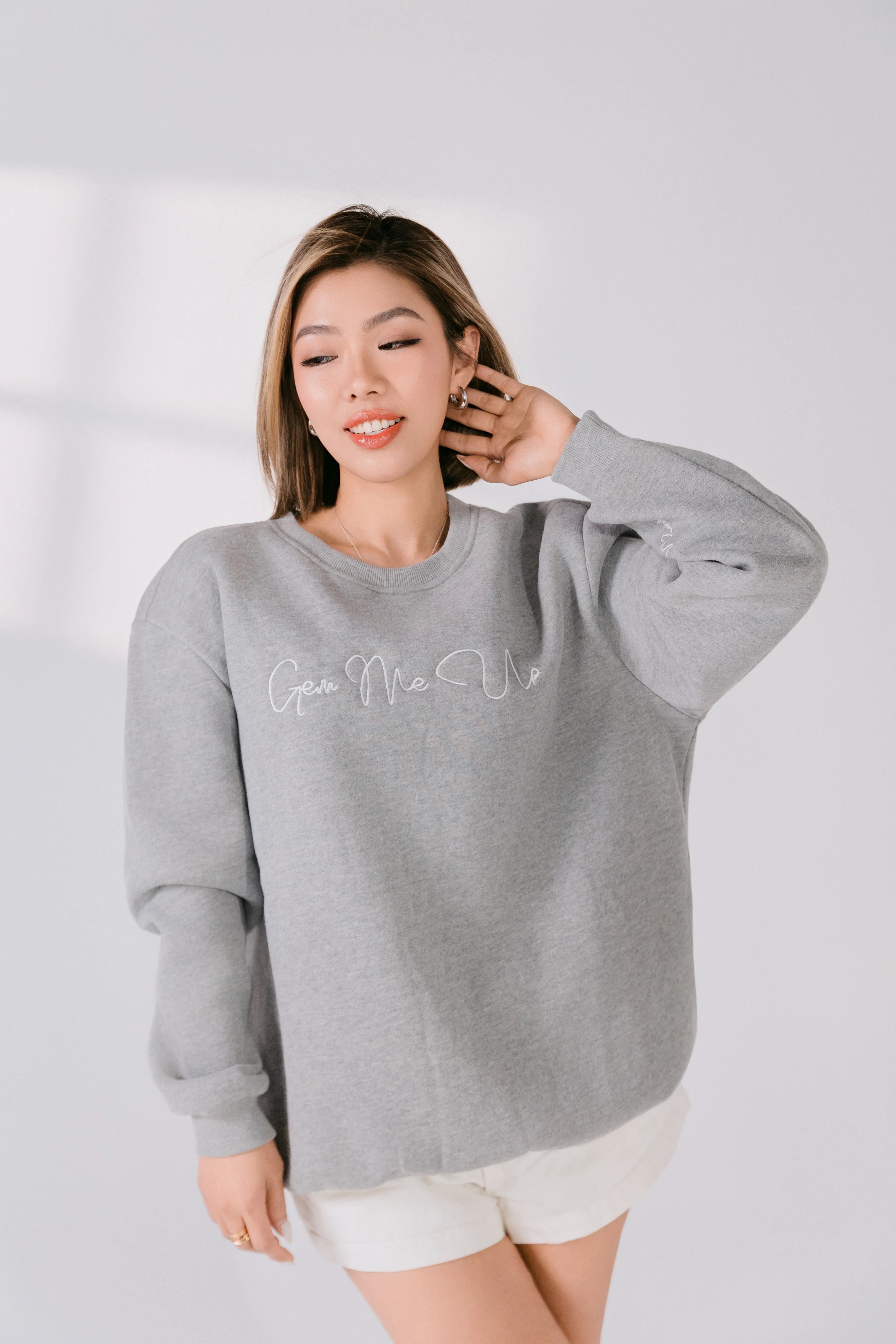 Model wearing heather gray “Gem Me Up” embroidered crewneck sweatshirt.