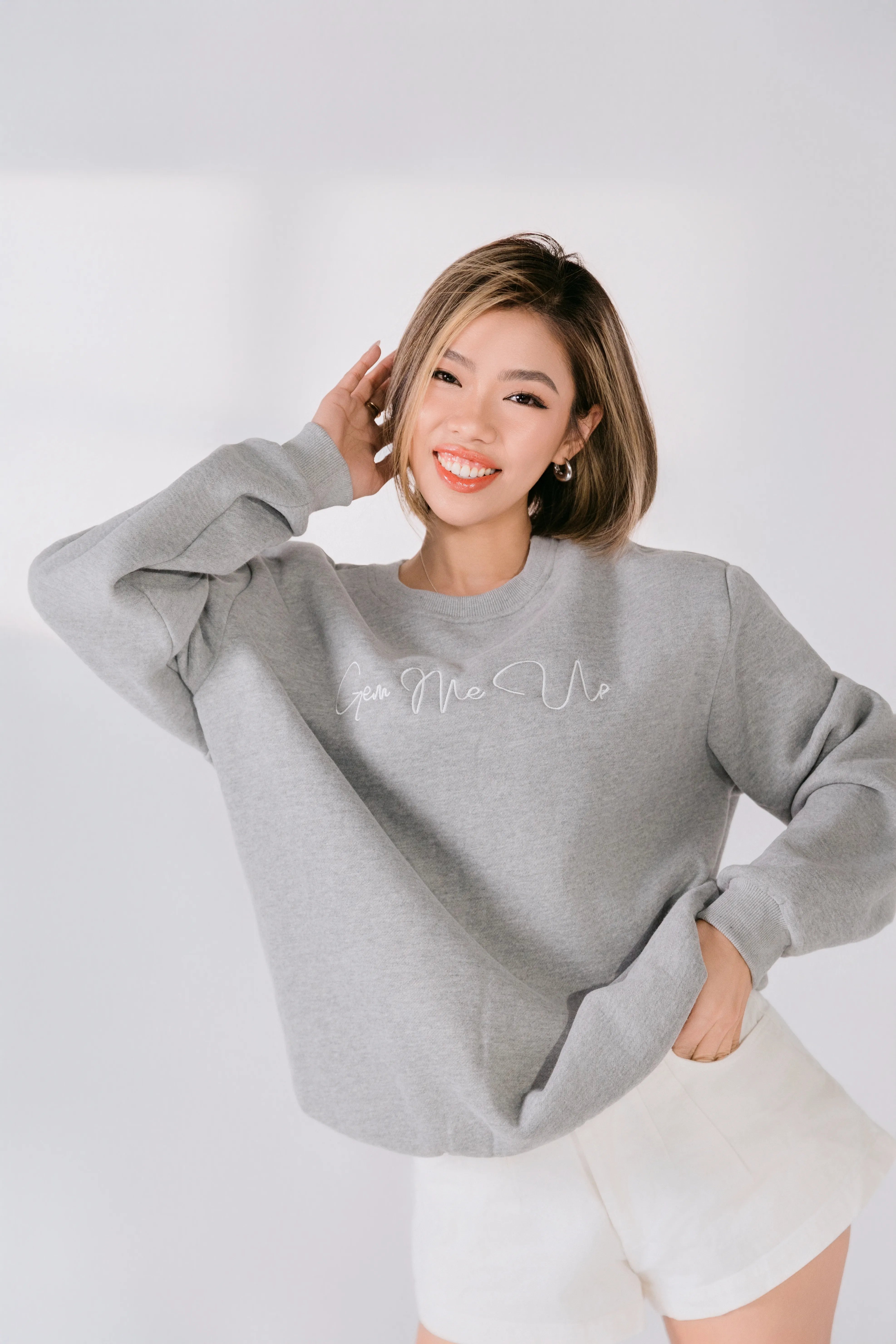 Woman wearing a gray sweatshirt with text on a white background