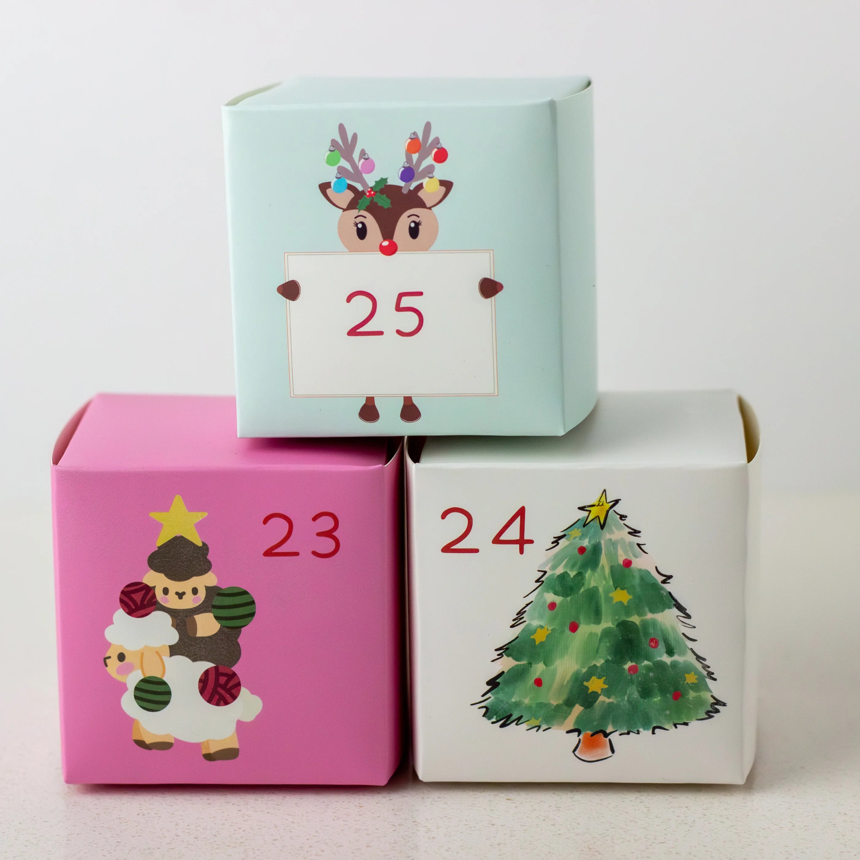 Three Christmas-themed boxes with numbers and festive designs on a white background