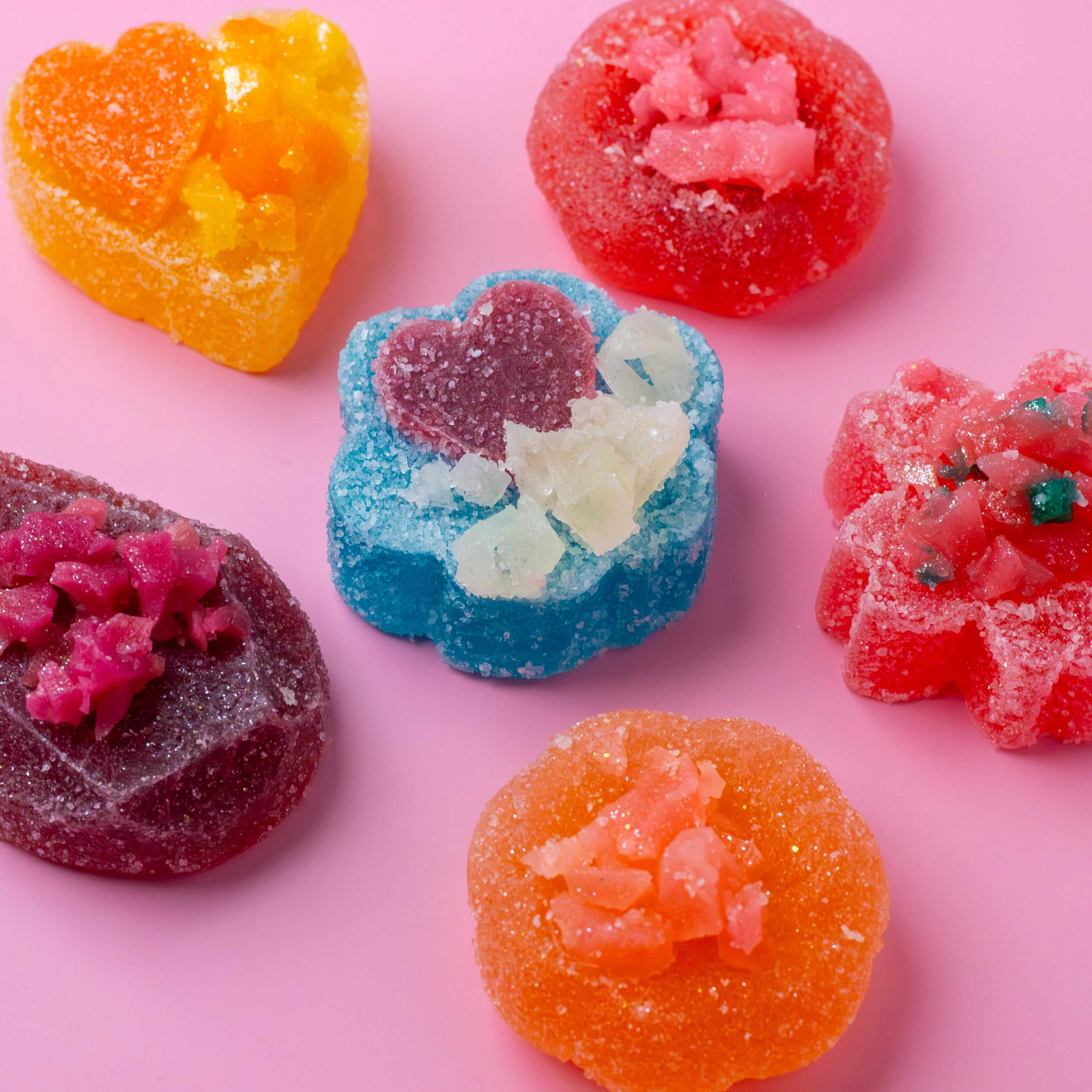 Colorful gummy candies on a pink background