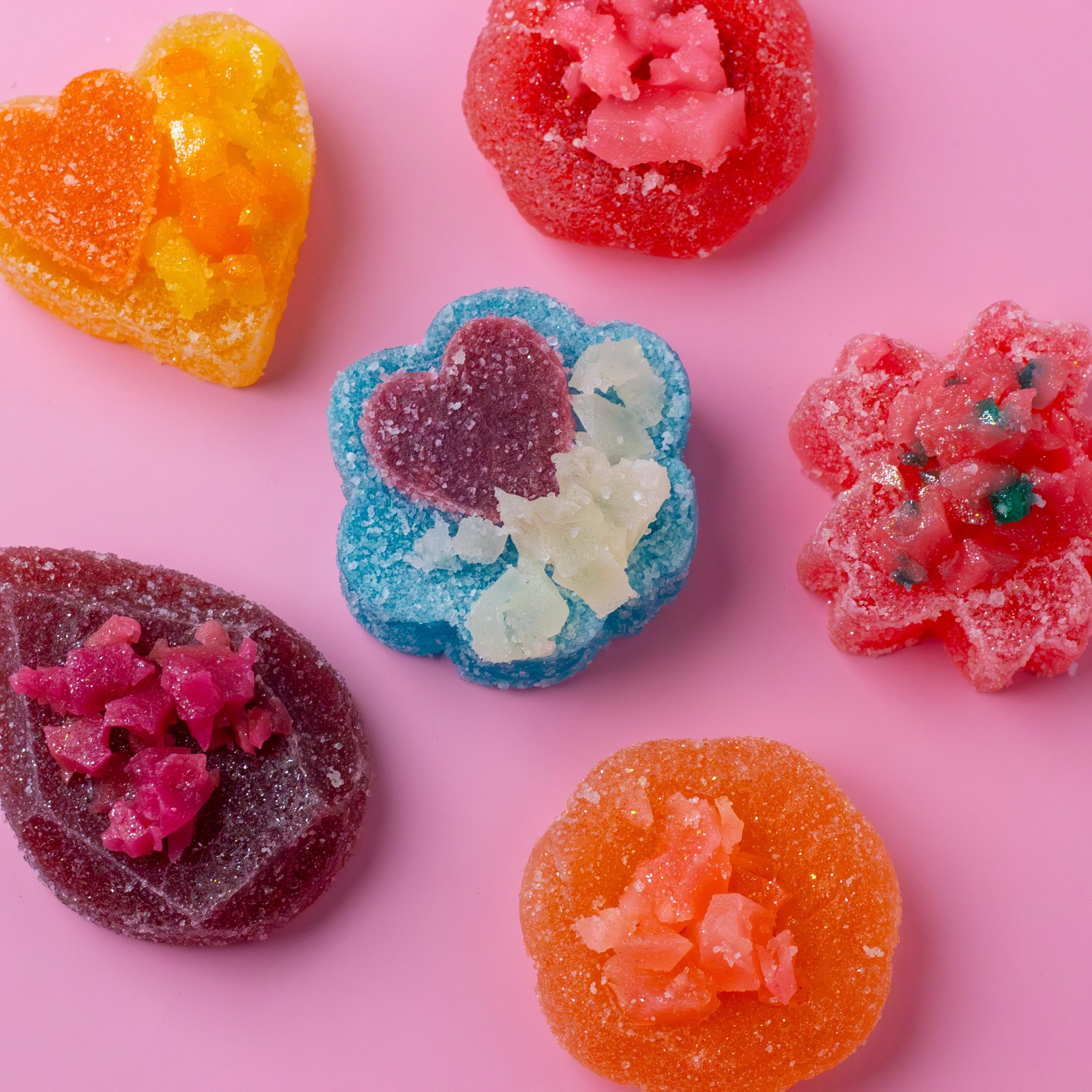 Colorful gummy candies on a pink background