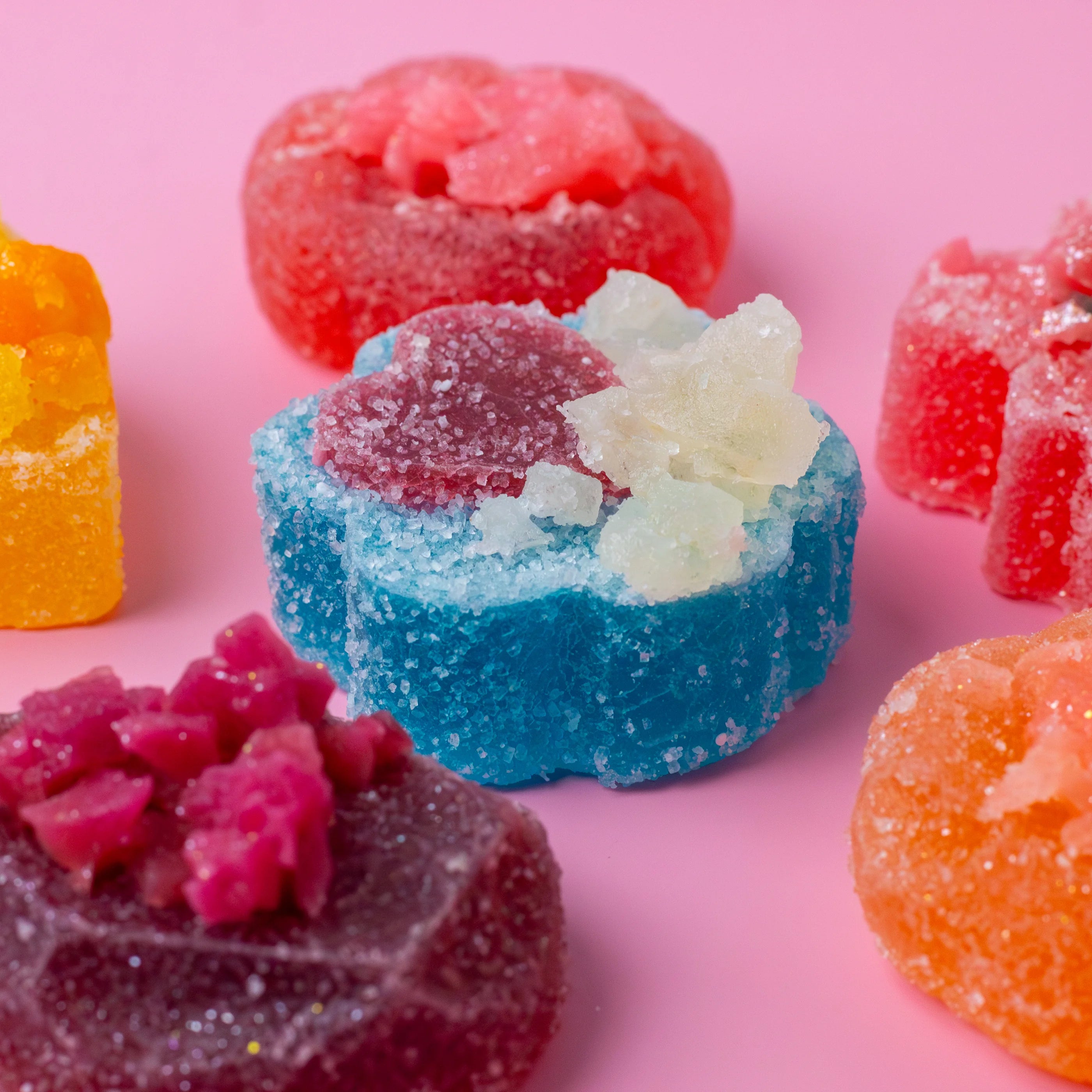 Colorful gummy candies on a pink background