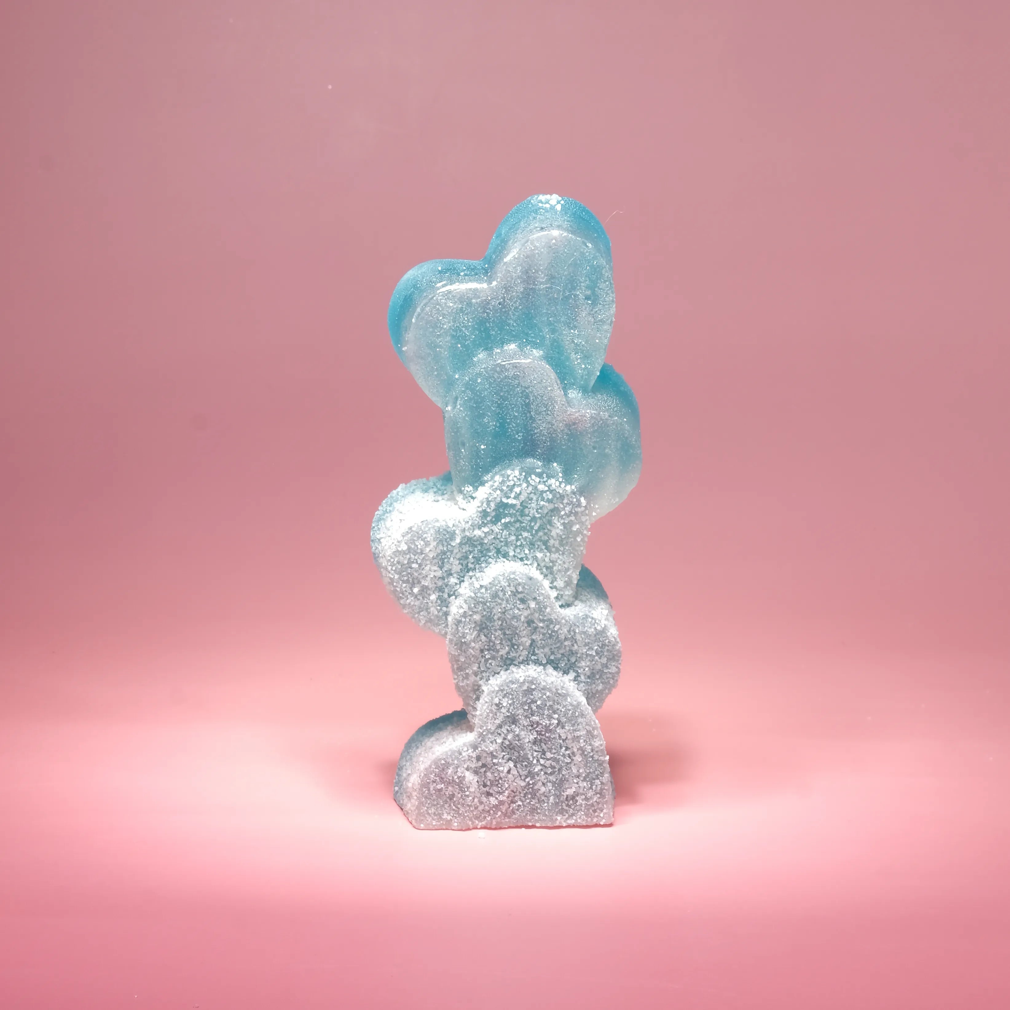 Blue and white decorative item shaped like a cloud on a pink background