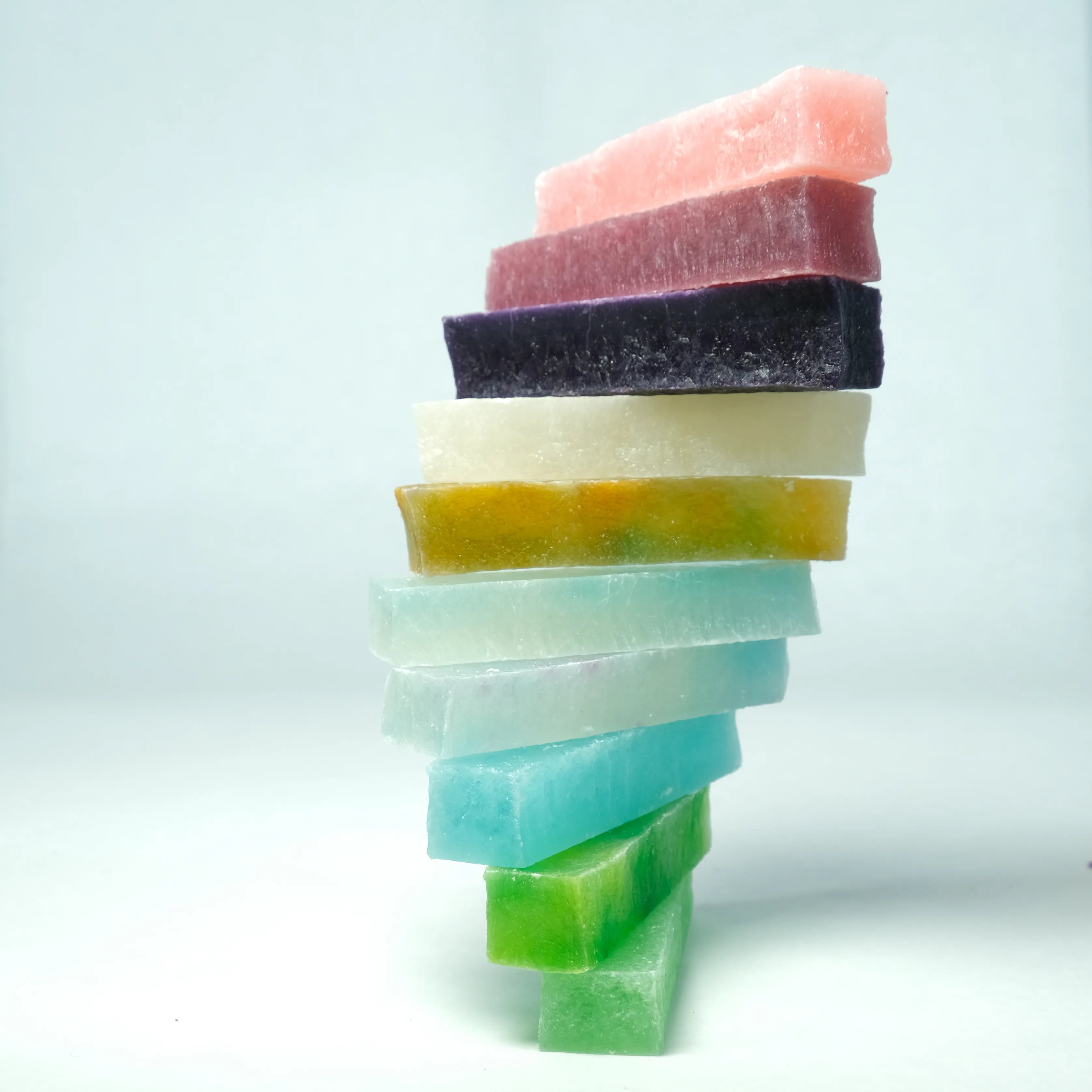 Stacked tower of multicolored Silky Gem Lunar Crystals candy bars, showcasing translucent textures and jewel-like colors against a clean background.