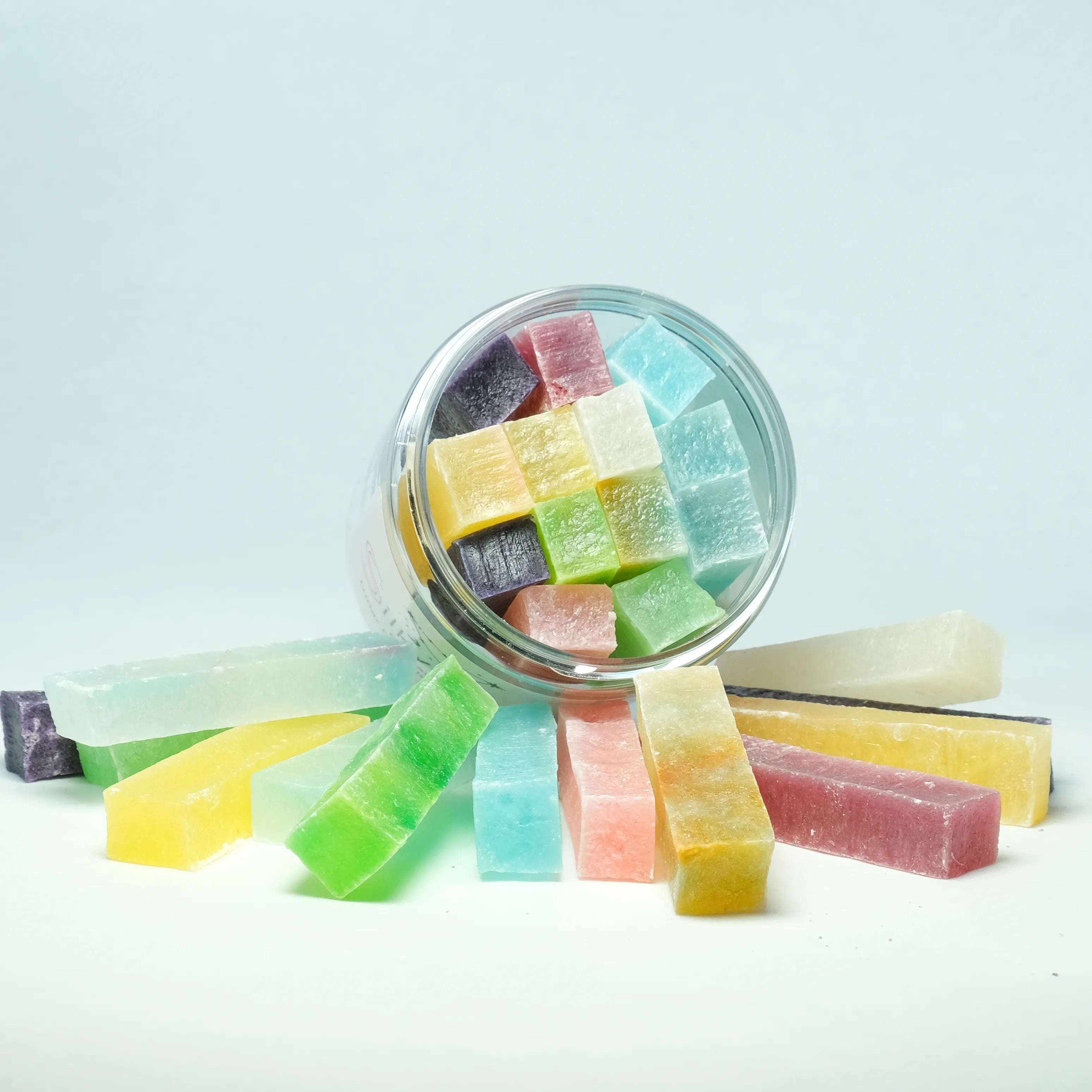 Top-down view of a Silky Gem Lunar Crystals jar tipped over, with pastel-colored crystal candies spilling out in a festive Lunar New Year display.
