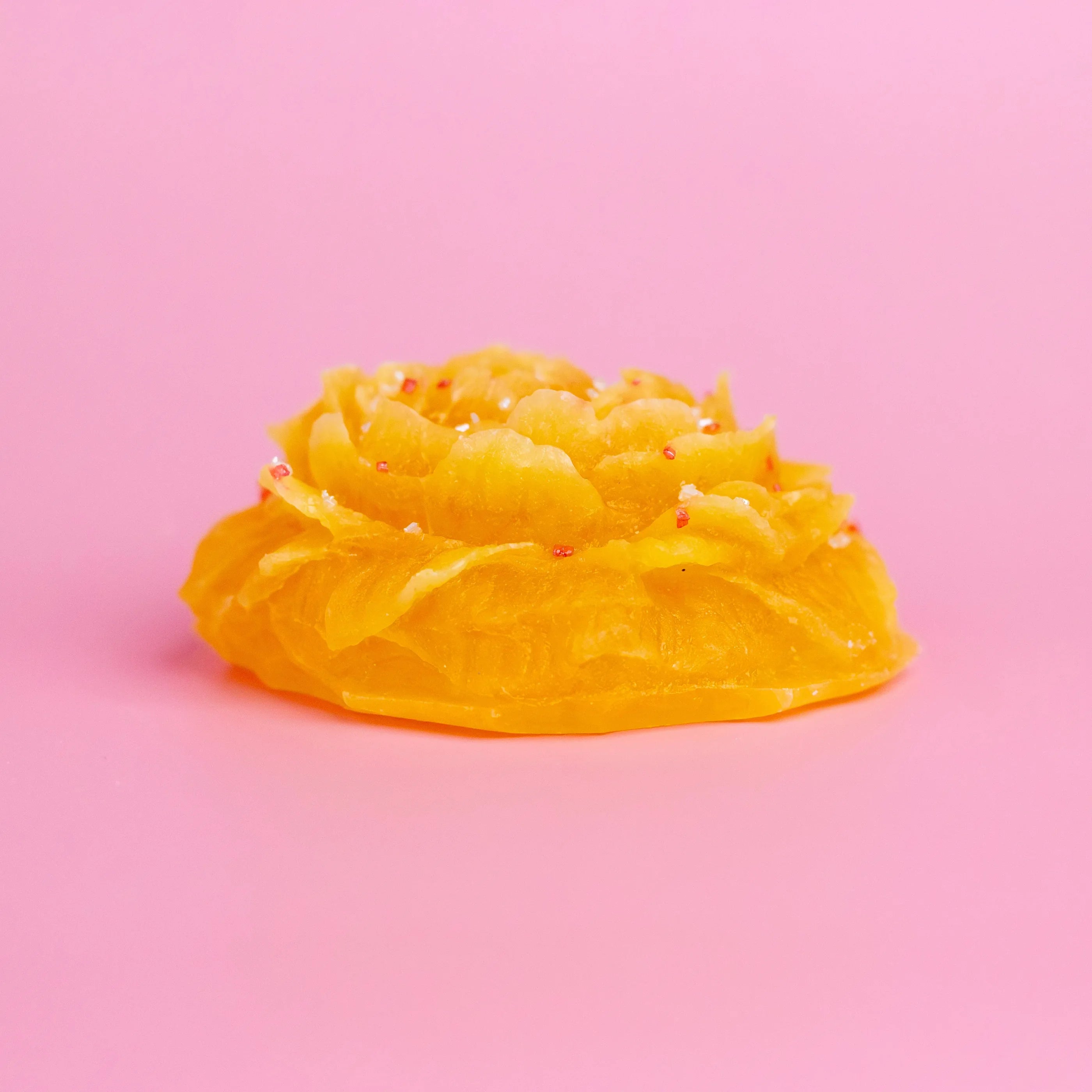 Yellow jelly-like substance on a pink background