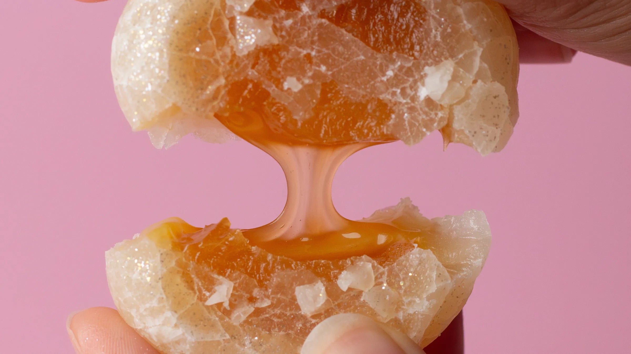 Peach with a white interior held against a pink background