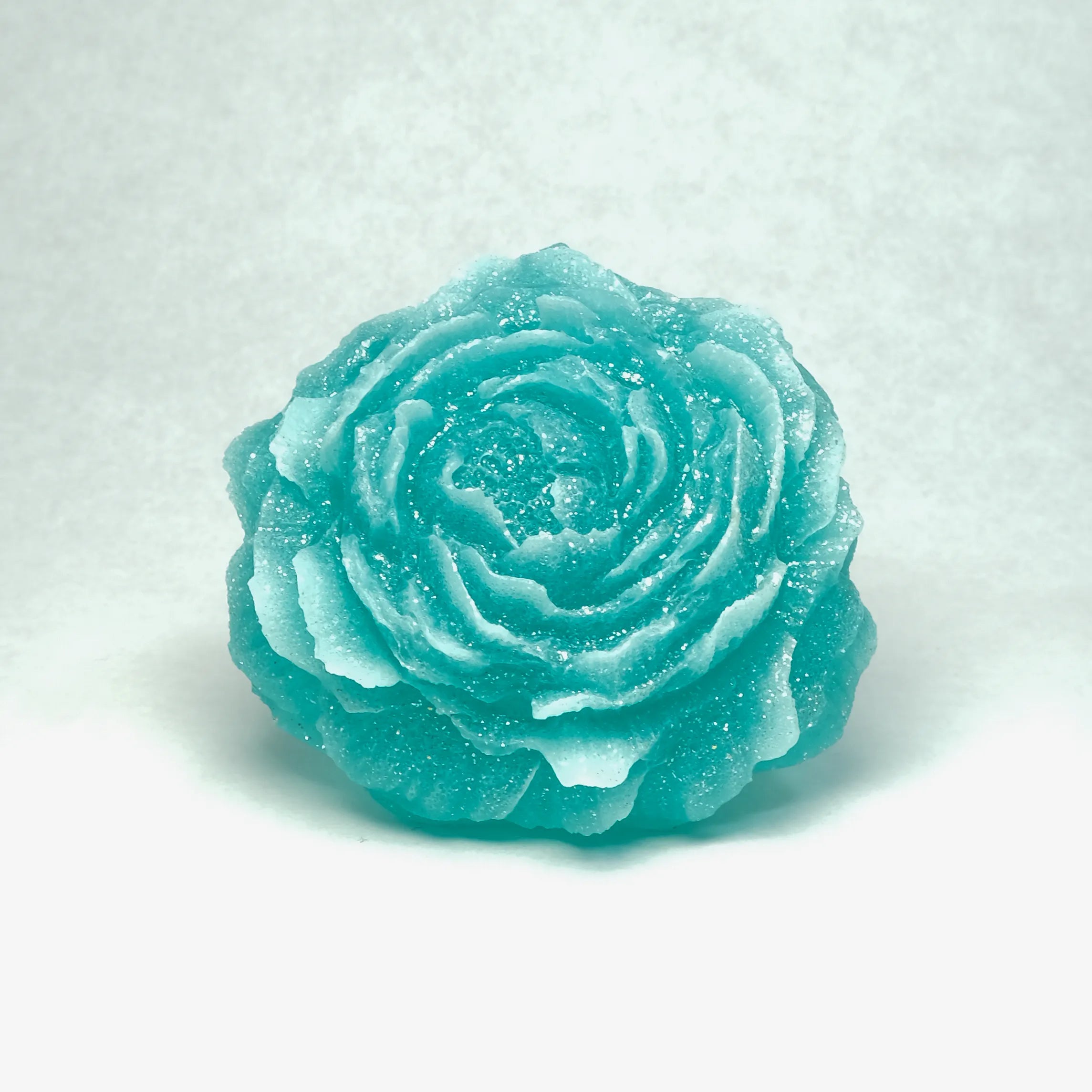 Turquoise rose-shaped soap on a white background