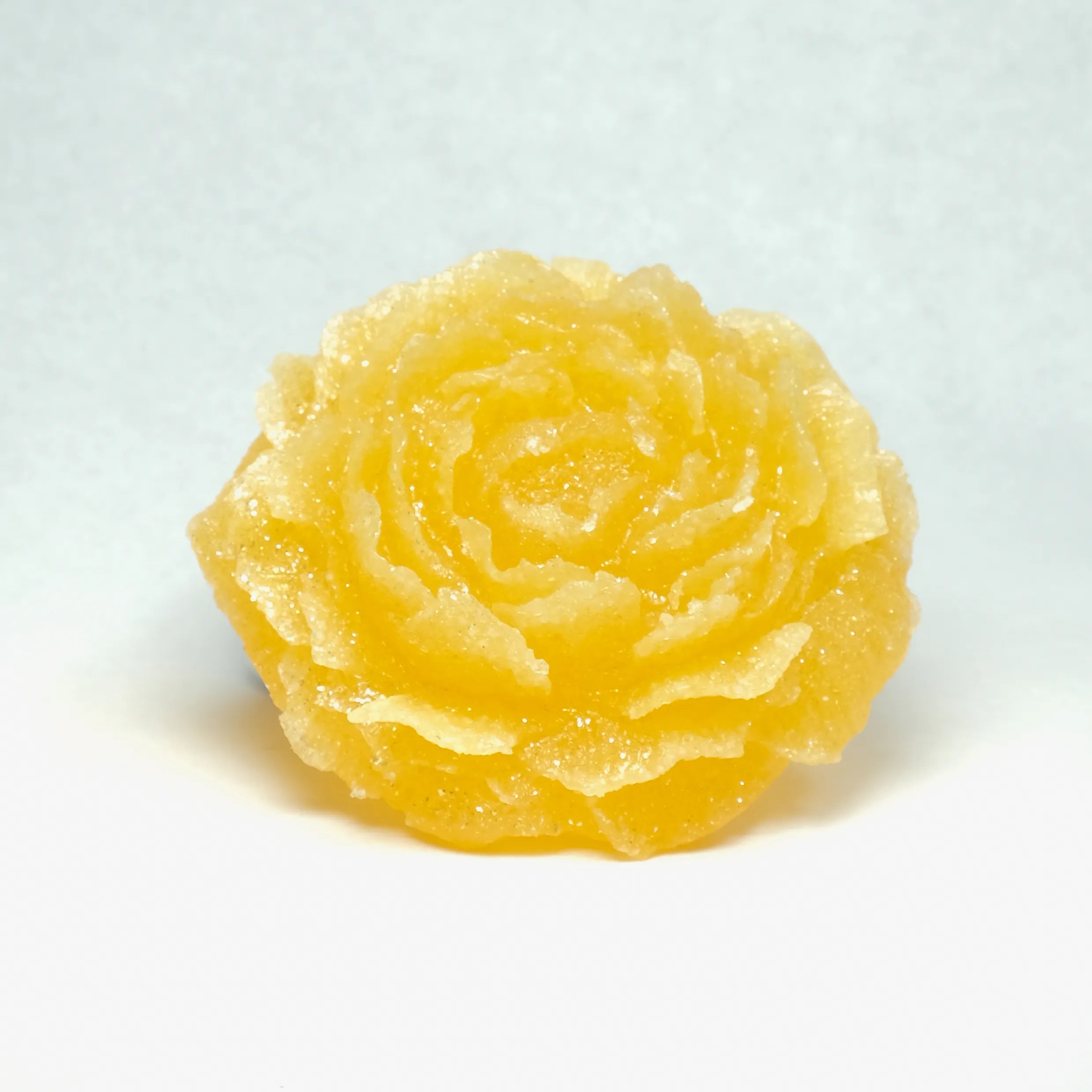 Yellow rose-shaped candy on a white background