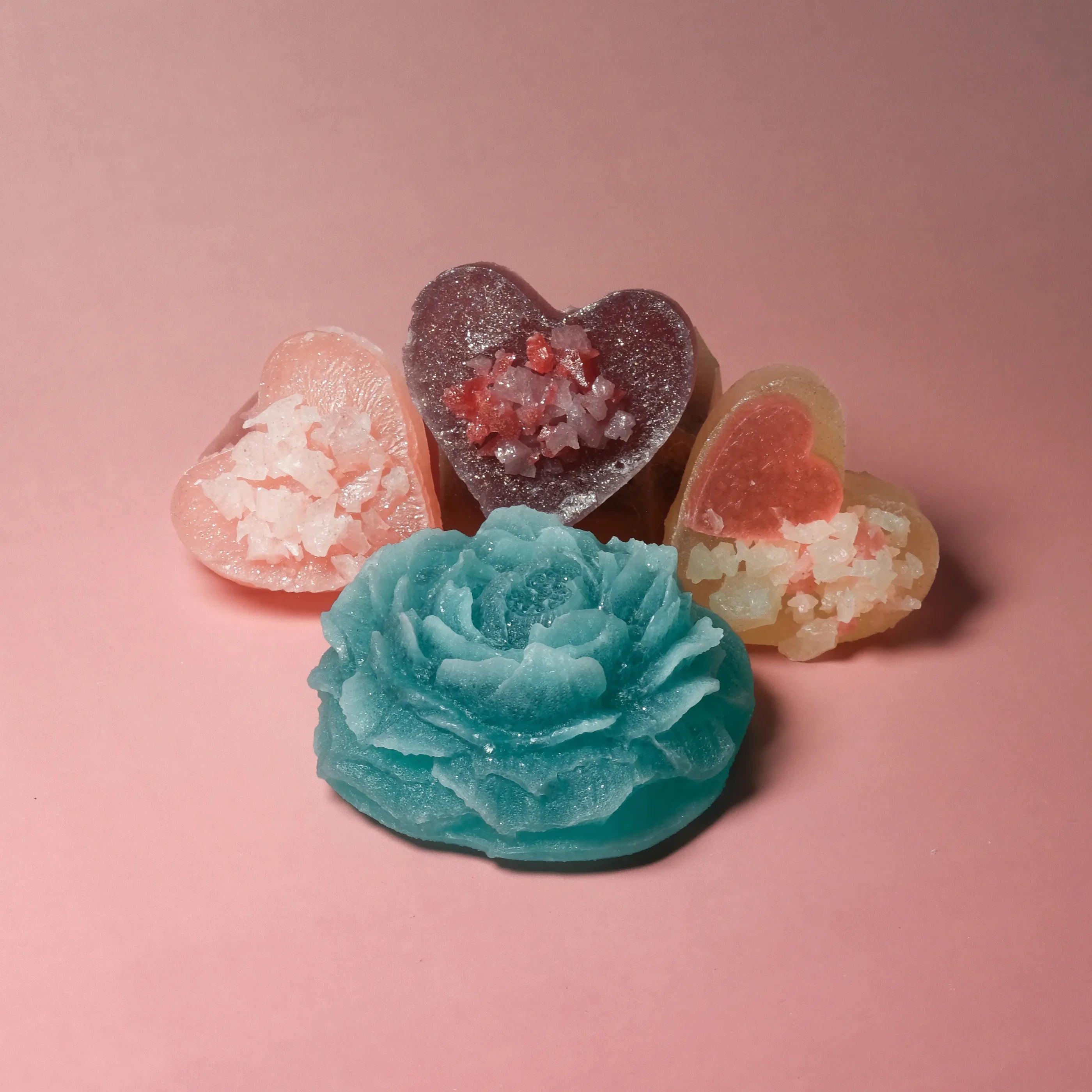 Colorful heart-shaped gummy candies on a pink background