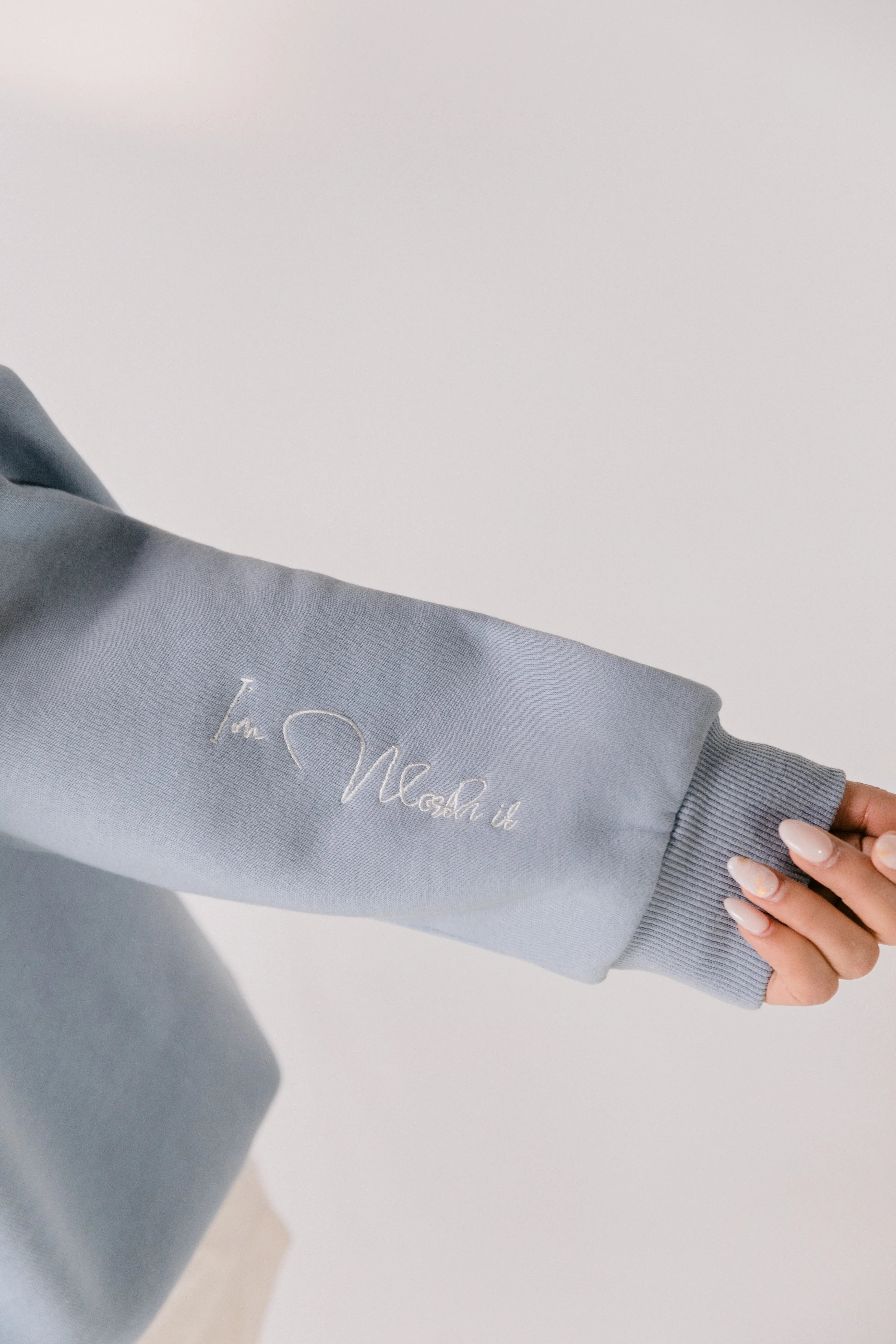 Close-up of sleeve embroidery reading “I’m worth it.”