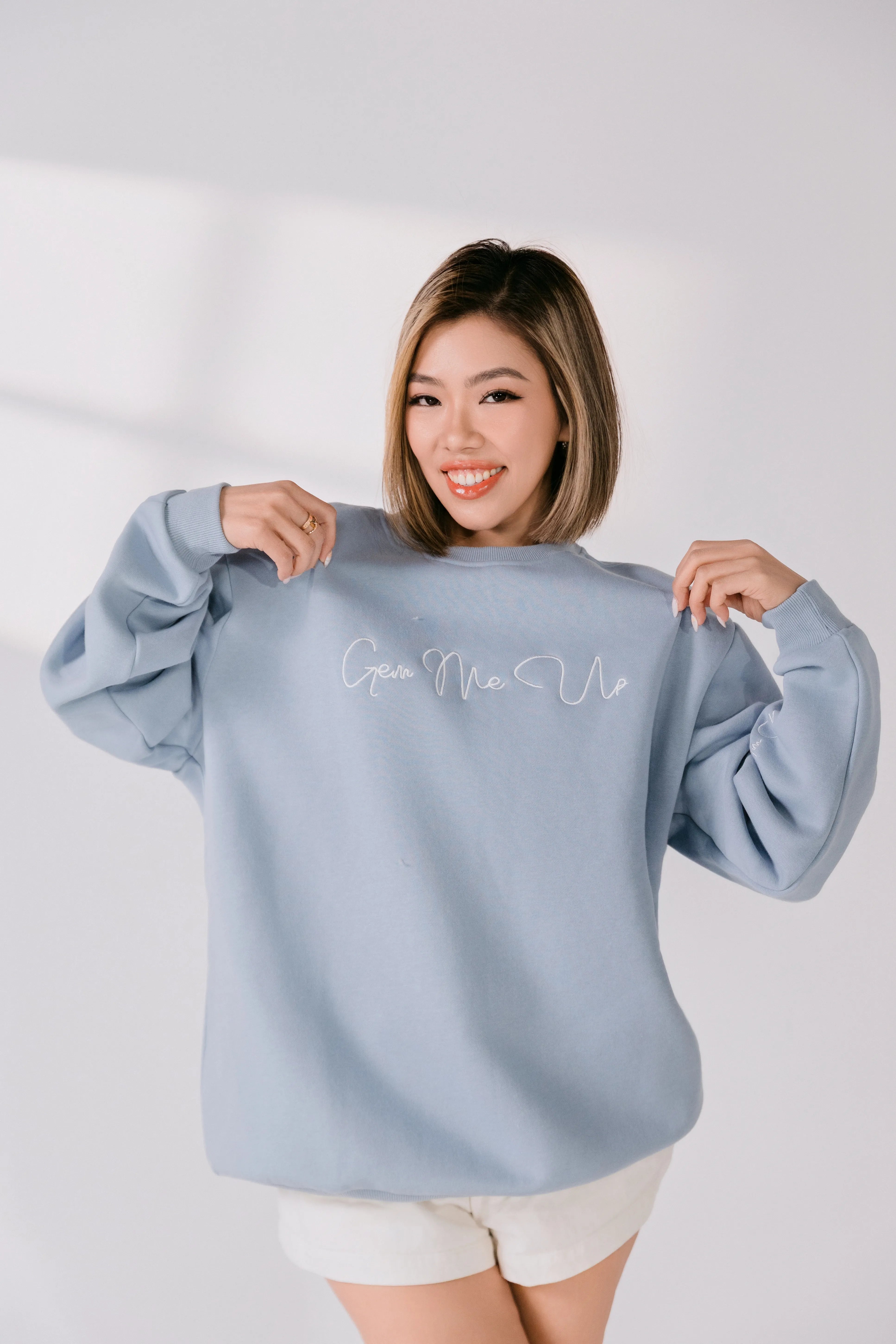 Three-quarter view of relaxed fit powder blue Gem Me Up crewneck.