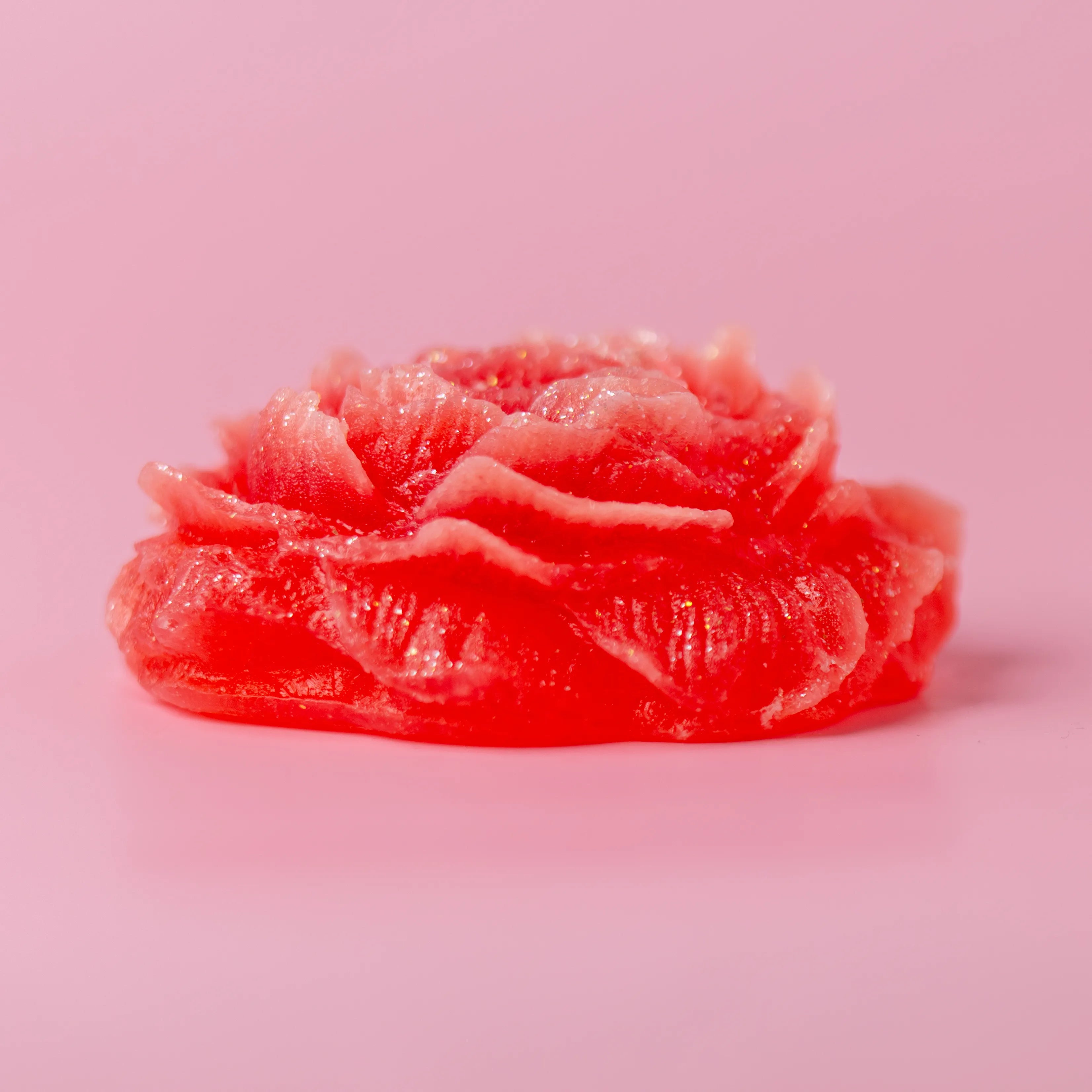 Pink rose-shaped candy on a pink background