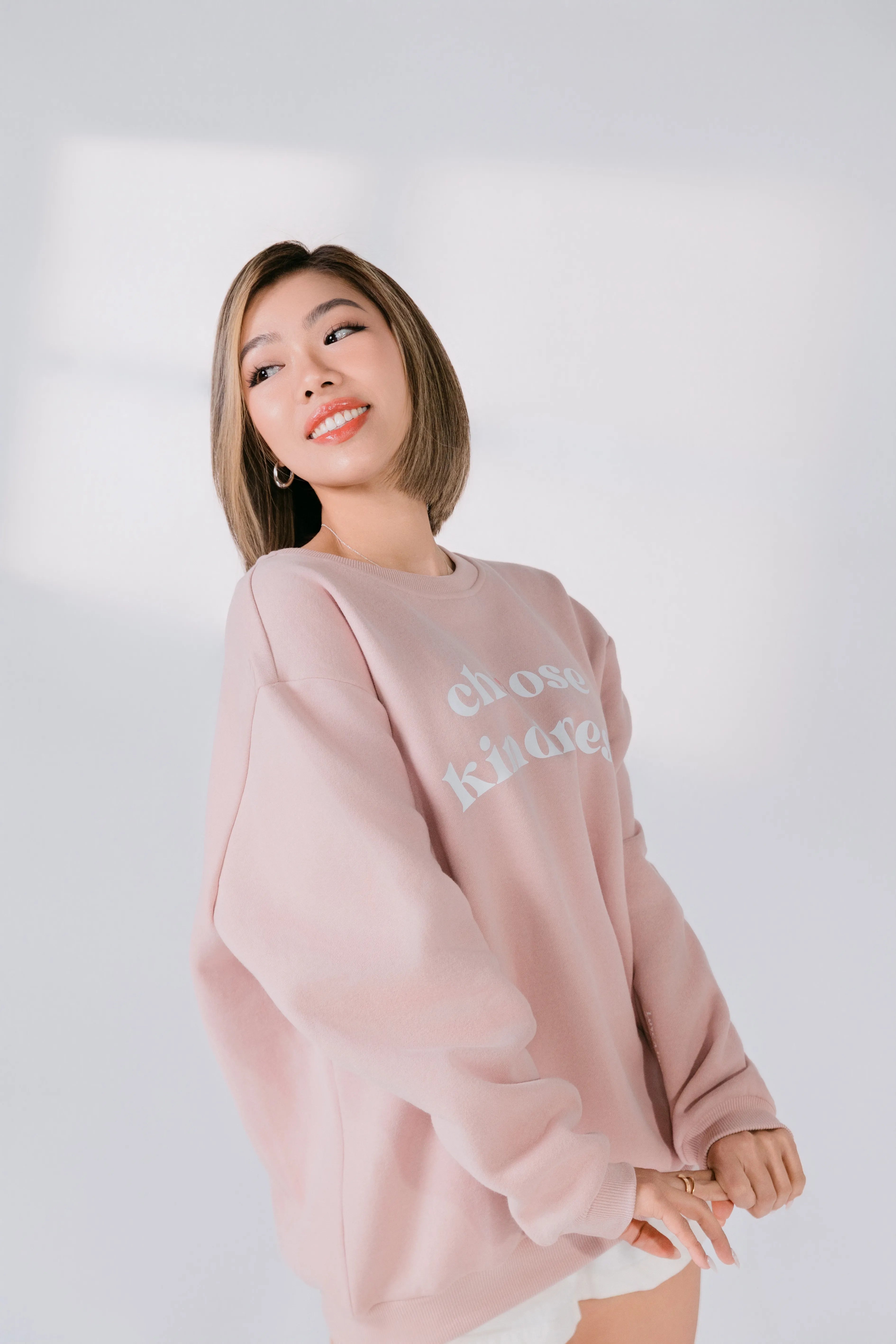 Three-quarter angle of blush pink cotton poly blend crewneck.