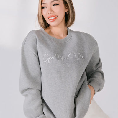 Person wearing a gray sweatshirt with 'Give Me Me' text on a white background
