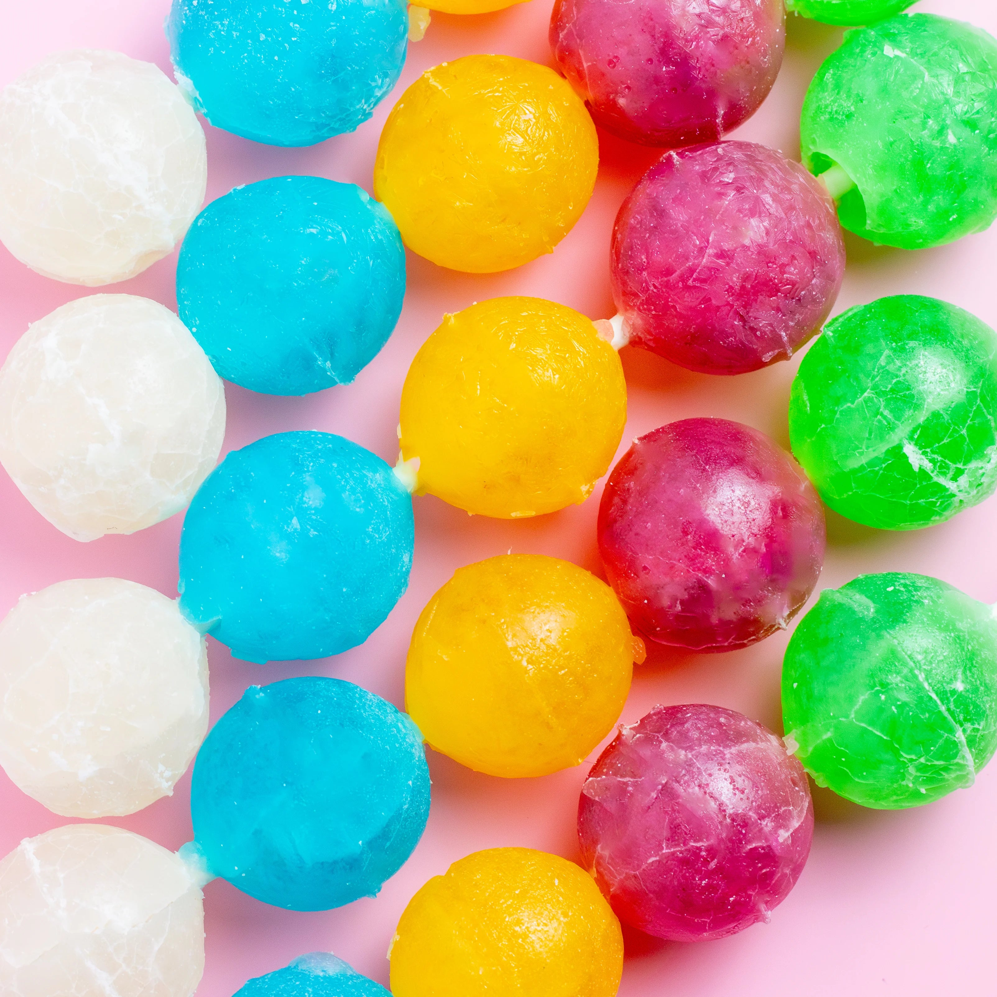 Colorful gumballs on a pink background