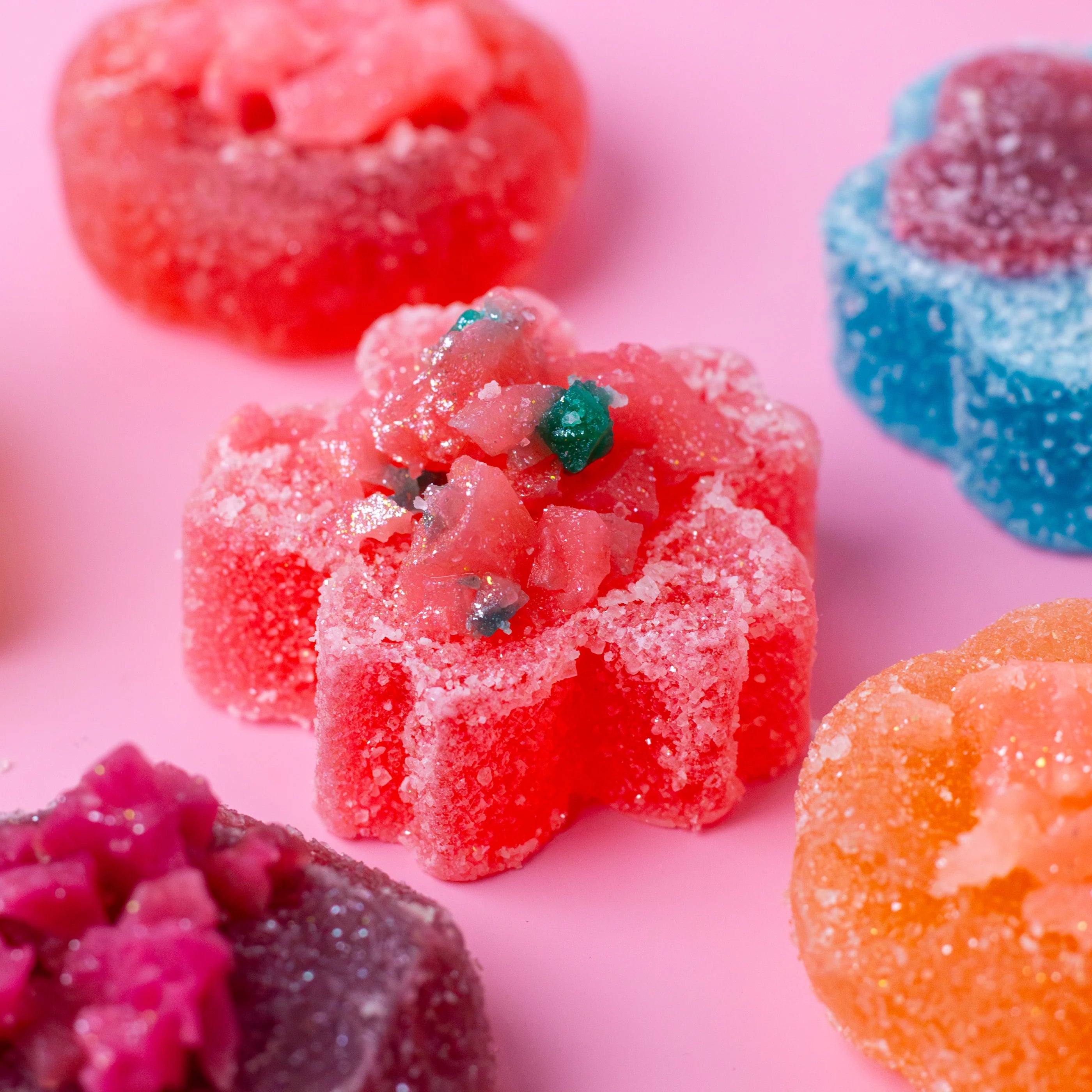 Colorful gummy candies on a pink background