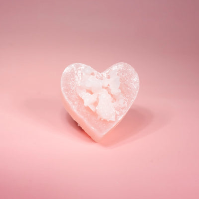 Heart-shaped Love at First Bite crystal candy on a pink background