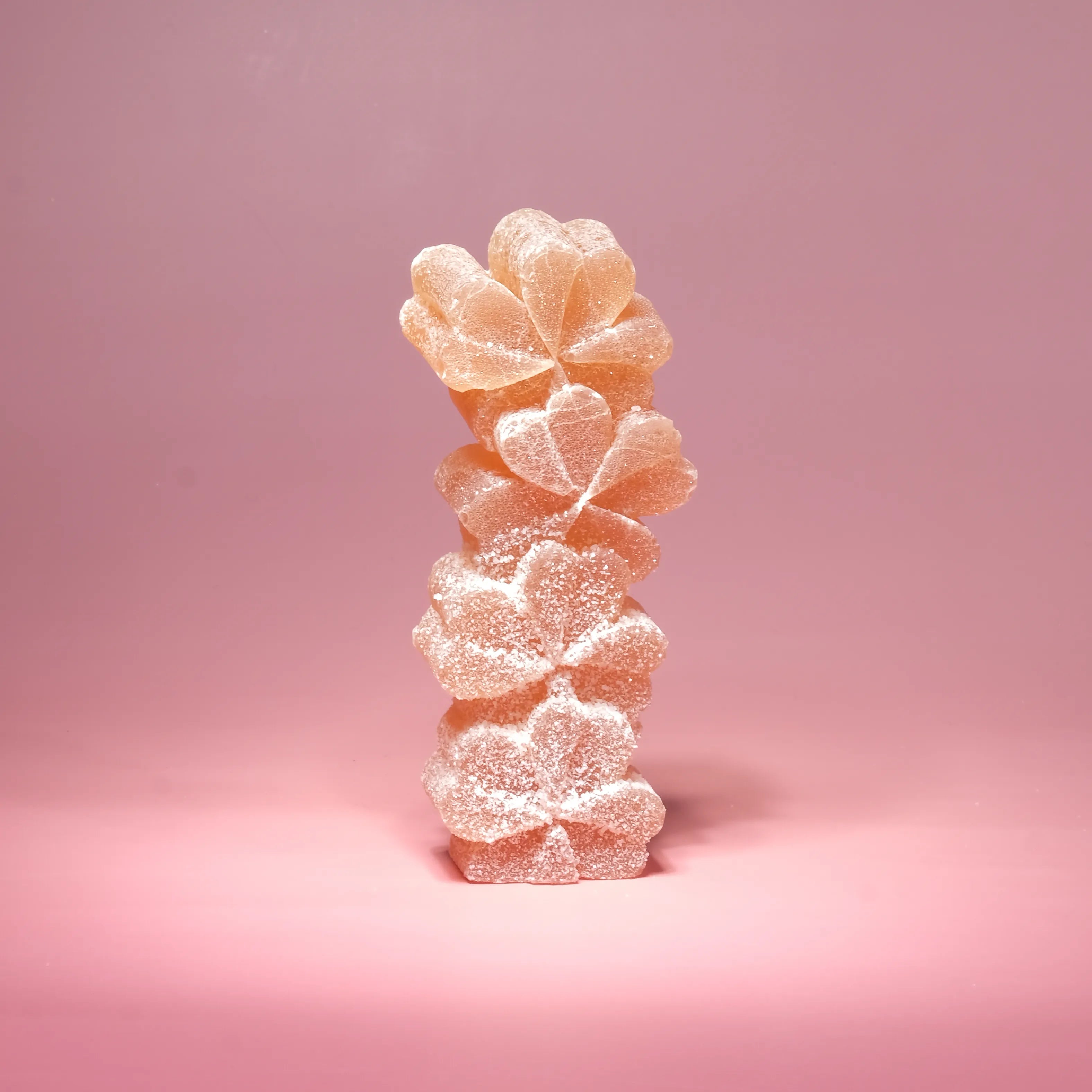 Gummy candy shaped like a pineapple on a pink background