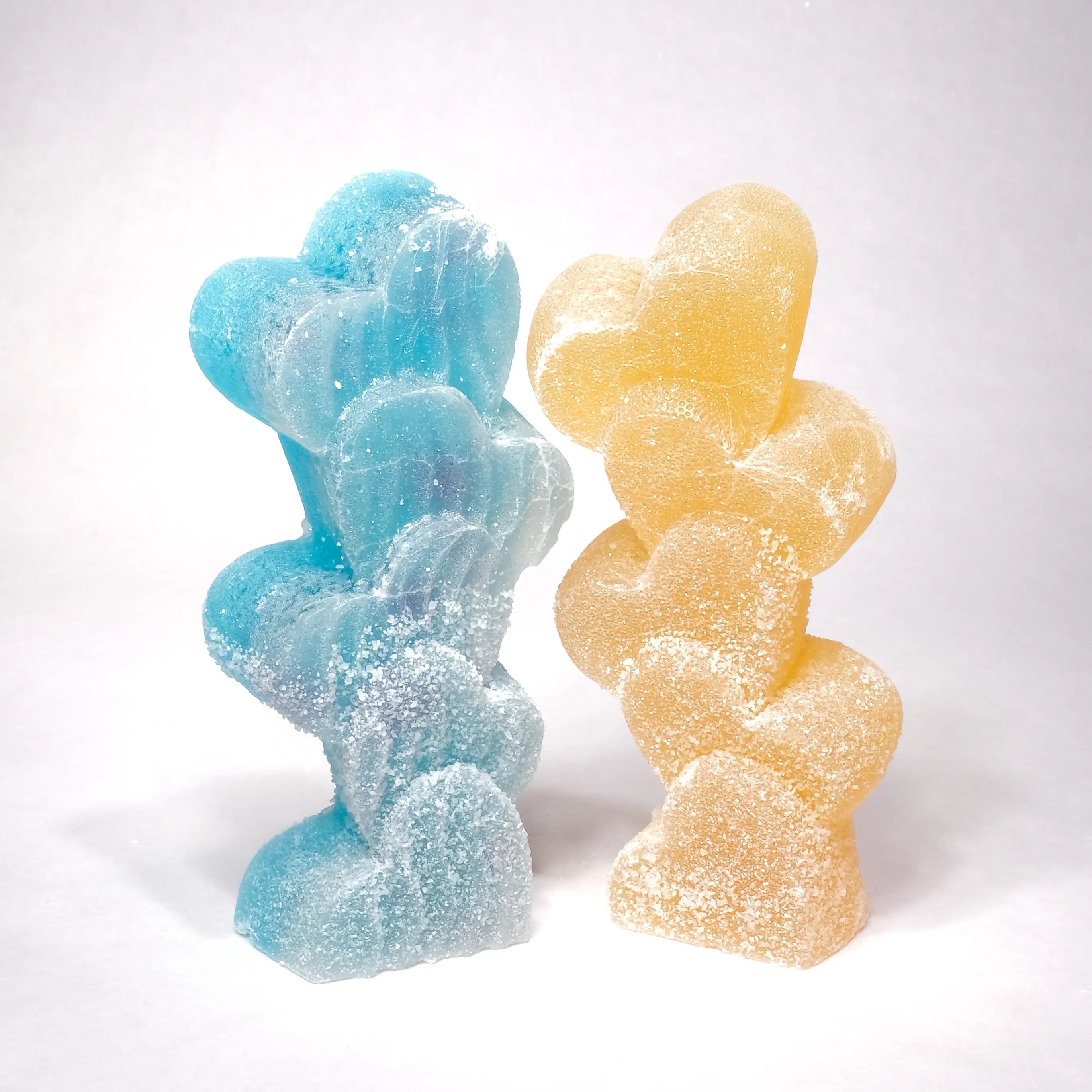 Two gummy bear-shaped candies, one blue and one yellow, on a white background.