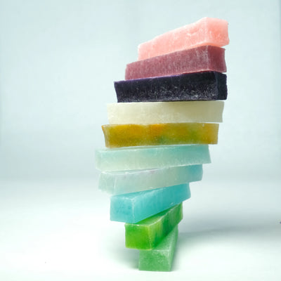 Stacked tower of multicolored Silky Gem Lunar Crystals candy bars, showcasing translucent textures and jewel-like colors against a clean background.