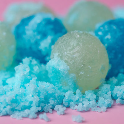 Morgan's Sour Spheres lemon and blue raspberry crystal candies on pink background