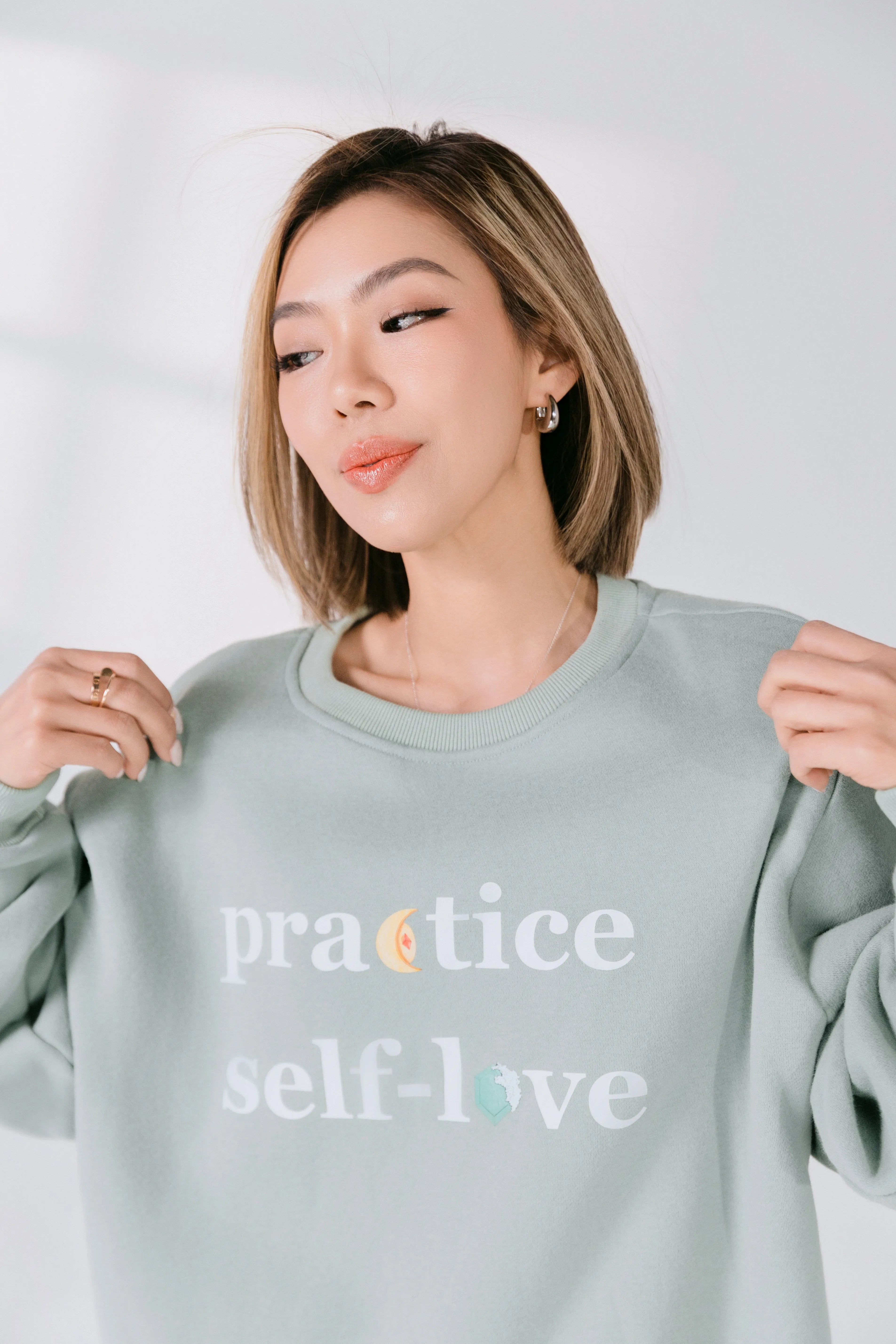 Close-up of front graphic reading “practice self-love” with subtle accent details.