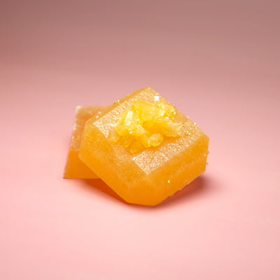 Passion fruit flavored Silky Gem crystal candy with a vibrant yellow-green translucent cube and crystalline sugar topping.