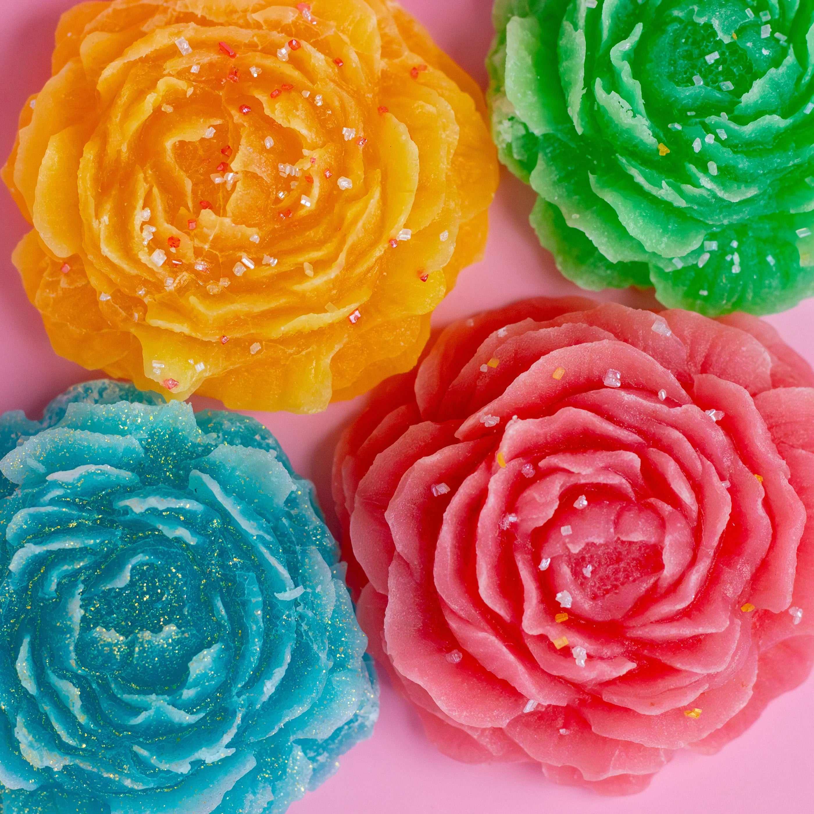 Colorful flower-shaped candies on a pink background