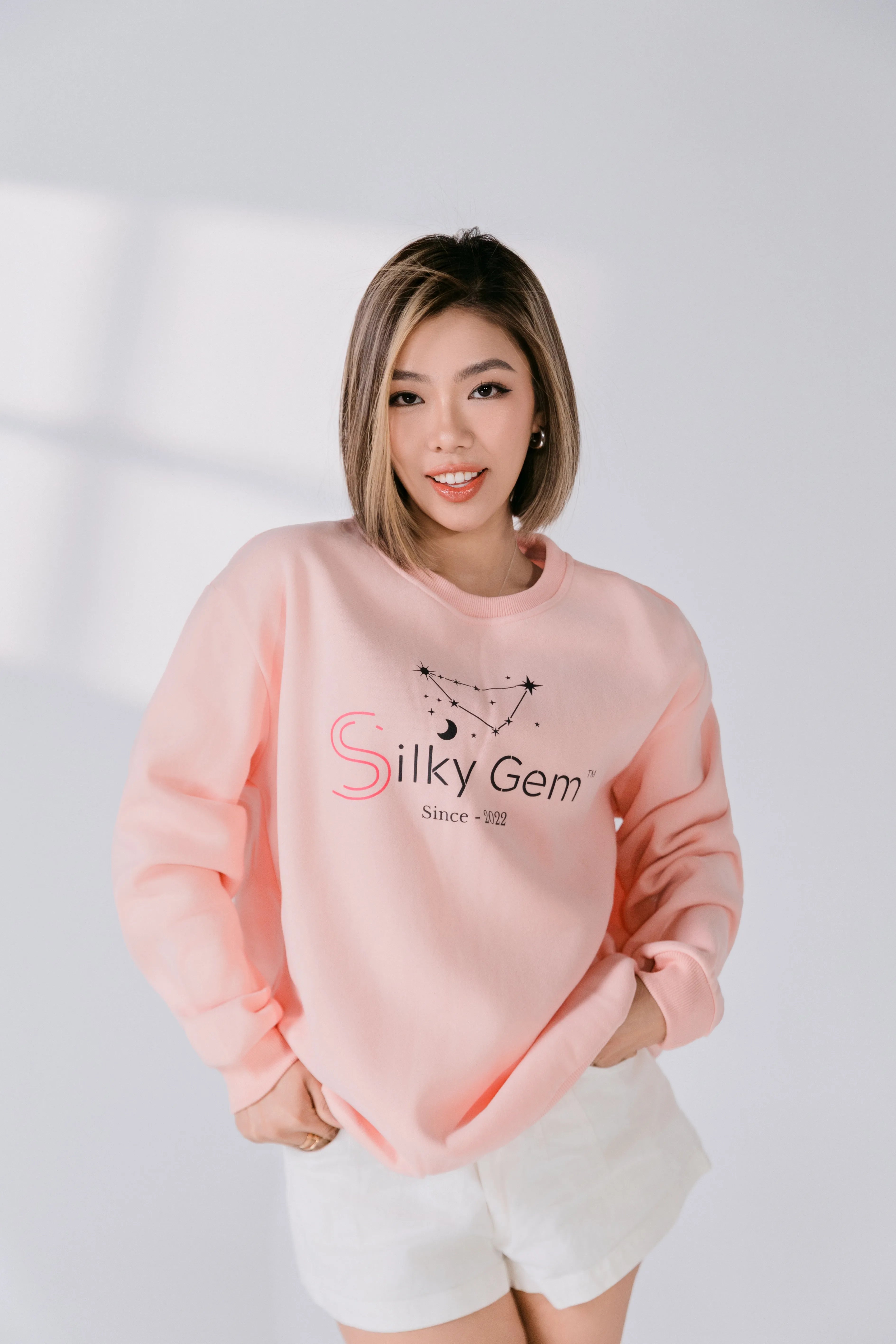 Lifestyle image of model smiling in Silky Gem constellation crewneck.