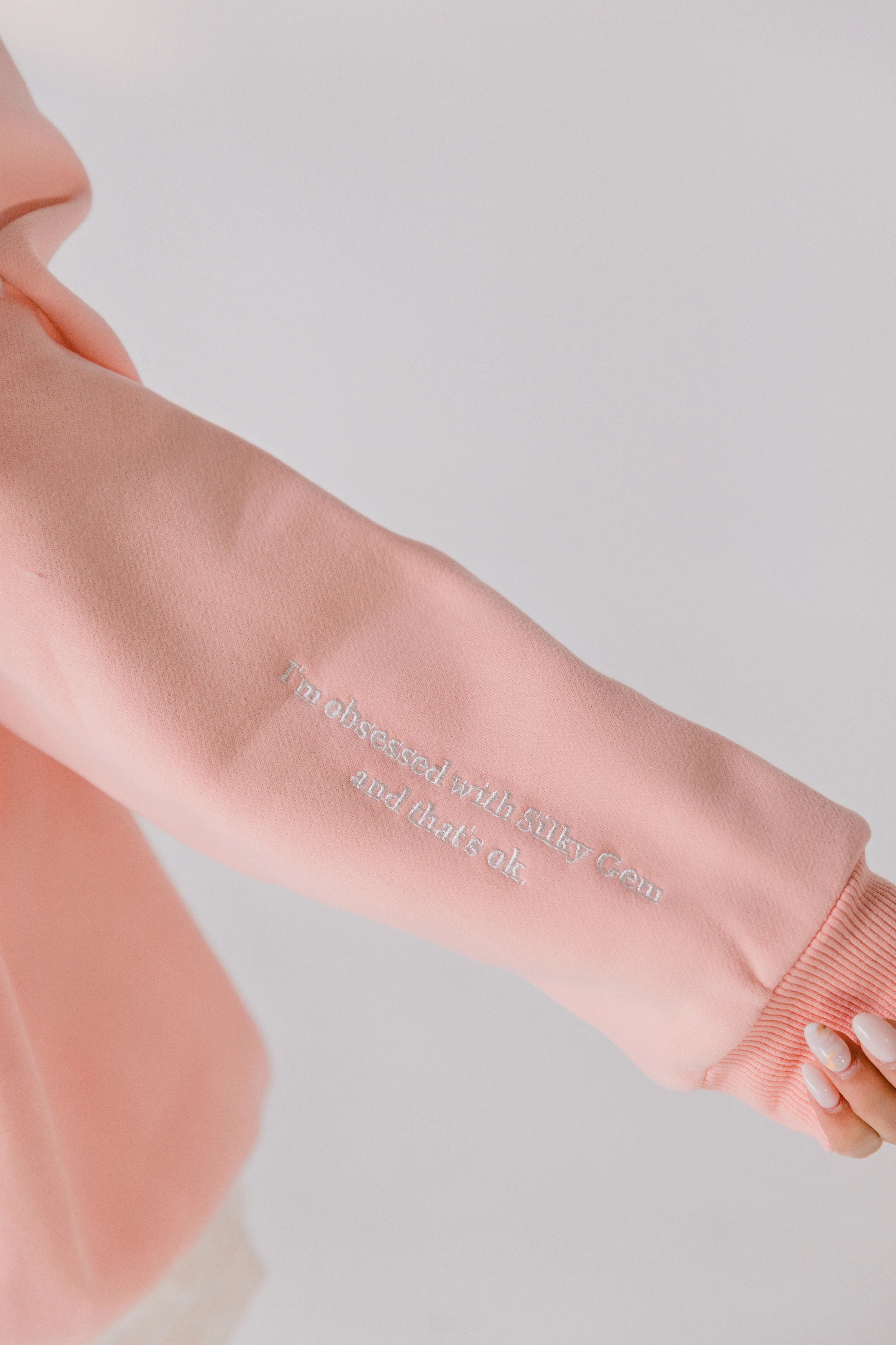 Close-up of sleeve embroidery reading “I’m obsessed with Silky Gem and that’s ok.”