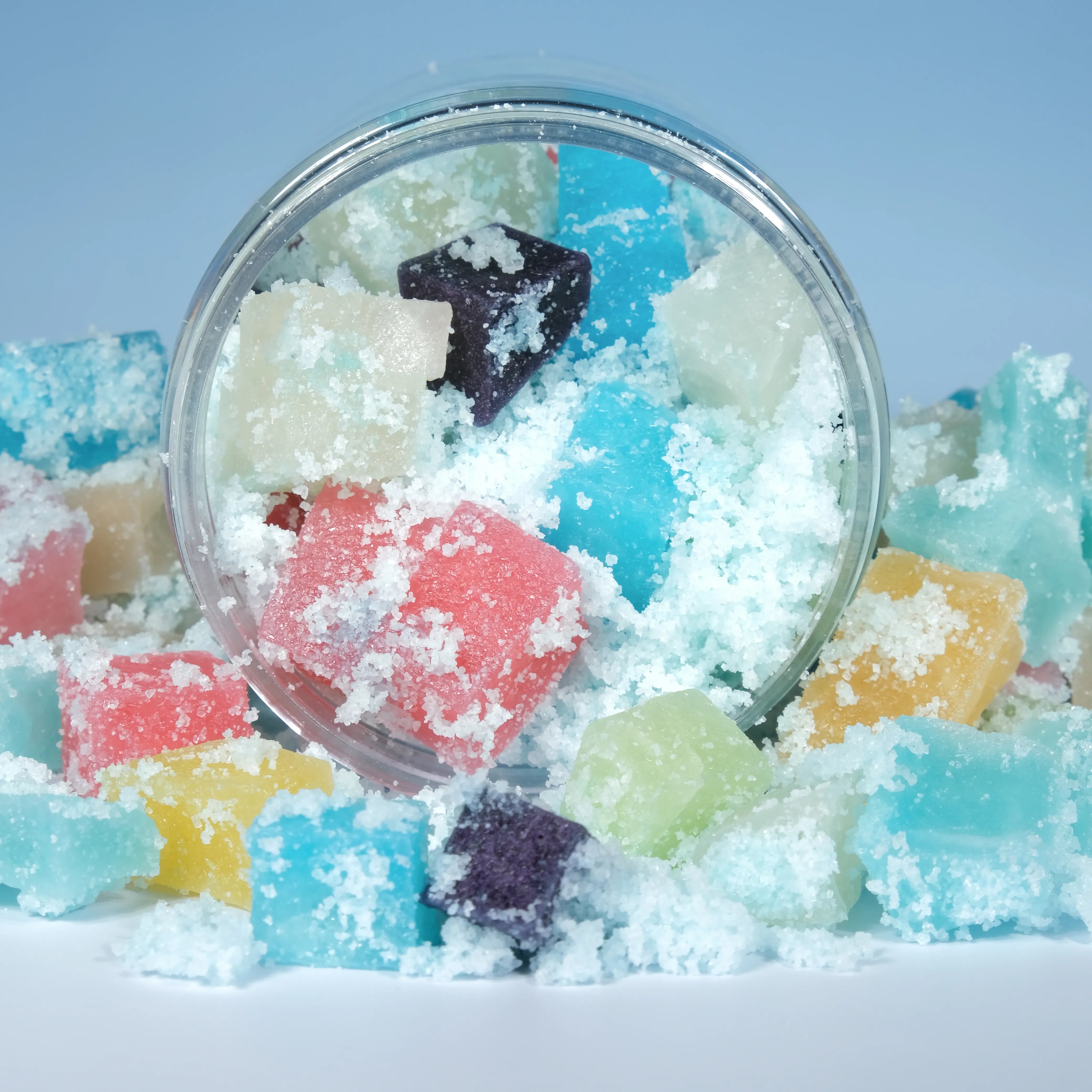 Mini crystal candies spilling from a clear jar, covered in glittering sour sugar for an extra sour candy experience.