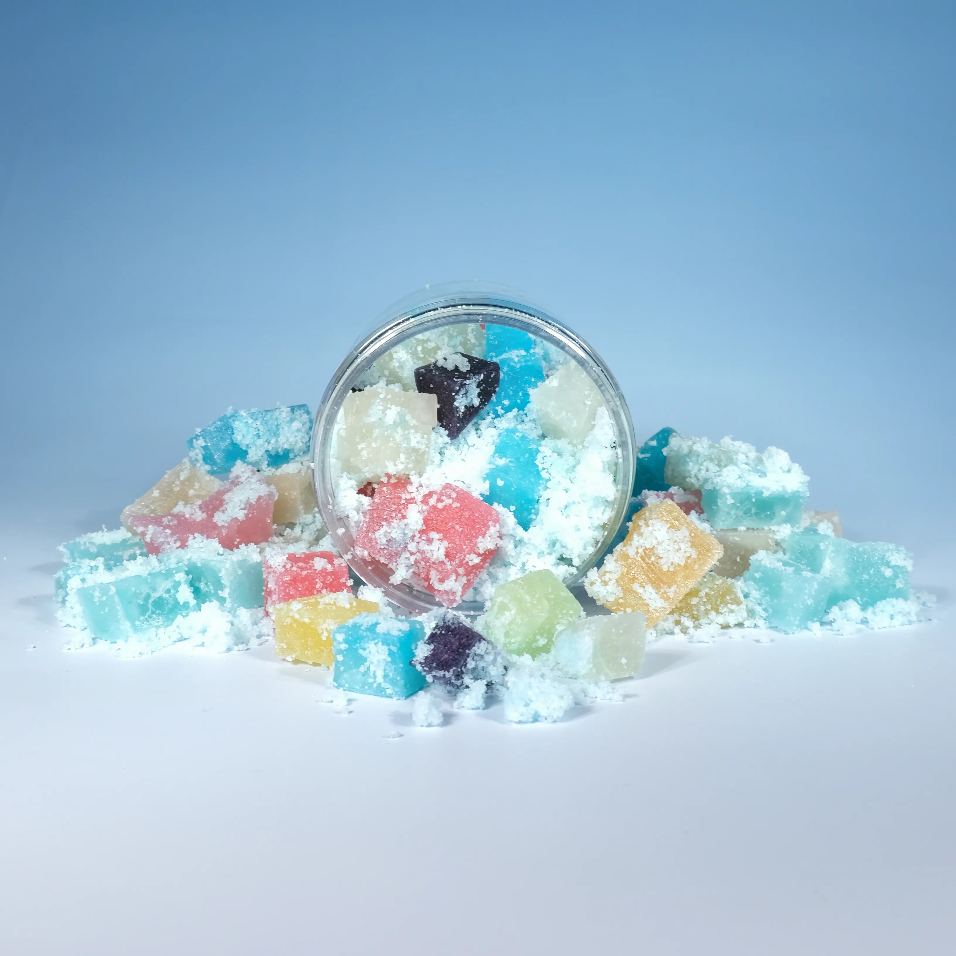 Top view of mini crystal candies inside an open jar, dusted with shimmering sour sugar crystals in bright pastel colors.