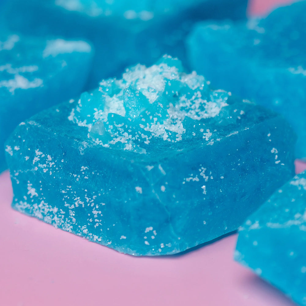 Sour Blue Raspberry Lapis crystal candy with blue Sizzle Glitter on pink background