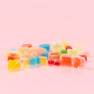 Assorted Silky Gem crystal candy pieces on a pink background.