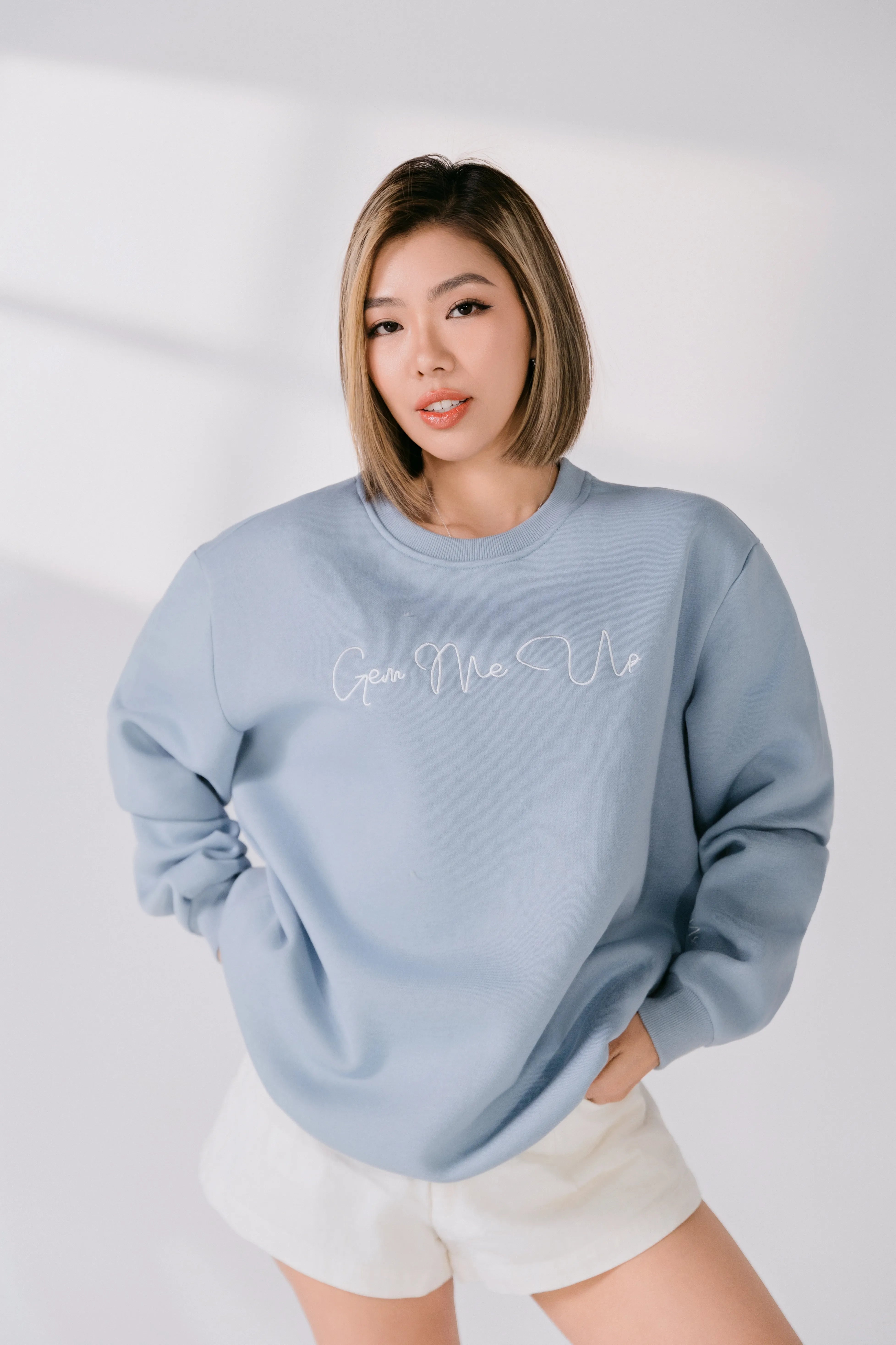 Model wearing powder blue “Gem Me Up” Silky Gem crewneck sweatshirt, front view.