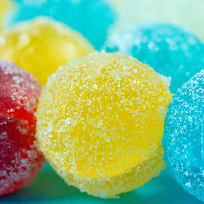 Close-up of Sizzle Pop sour crystal candies coated in Sizzle Glitter